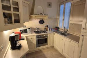 a kitchen with white cabinets and a stove top oven at Borgo San Frediano Hideaway in Florence