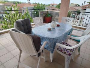 a table and chairs on a balcony with a table at Nansy's house in Áyios Pávlos