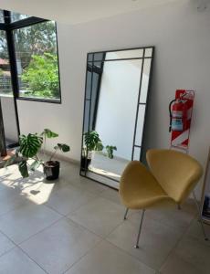 a living room with a chair and a mirror at Condominio lirondelle in La Falda