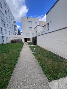 a walkway between two buildings in a yard at Maison de 100m2 a 5 minutes du centre de base du PSG in Poissy