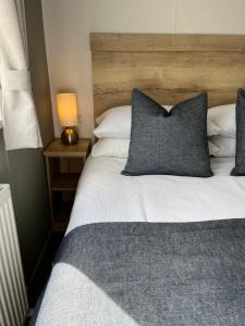 ウィットリー・ベイにあるEden Holiday Homeのベッドとテーブルの上にランプが置かれた寝室