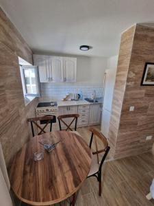 a kitchen with a wooden table and a table and chairs at Villa Regulus in Tivat