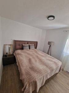 a bedroom with a large bed with a brown blanket at Villa Regulus in Tivat