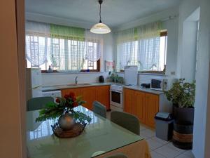 a kitchen with a table with a vase on it at VILLA APHRODITE SOUGIA apt1 in Kamária