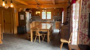 a kitchen with a wooden table and a refrigerator at Chalet Capilou linga 4 étoiles in Châtel