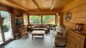 a living room with couches and a table in a cabin at Chalet Capilou linga 4 étoiles in Châtel
