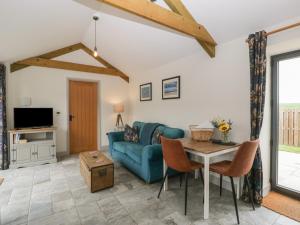 a living room with a blue couch and a table at The Cwtch in Bridgend