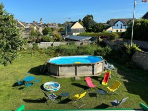 a group of chairs and a swimming pool in a yard at La Hacienda Negra in Saint-Jouan-des-Guérets