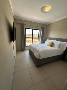a bedroom with a bed and a large window at Tranquility in Carlswald in Midrand +7 photos