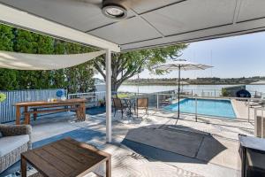 a patio with a table and an umbrella and a pool at Fish, Swim, Relax Moses Lake Gem with Outdoor Oasis in Moses Lake