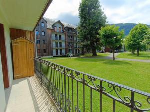 a balcony with a wooden door and a park at La Bicyclette, T2, wifi, parking, balcon, 4 personnes in Luchon