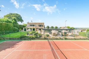 a tennis court in front of a house at Country Retreat with Grounds & Leisure Facilities in Brighouse