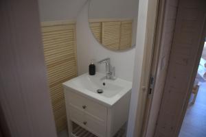 a bathroom with a white sink and a mirror at Szumiące Drzewa in Debina
