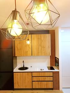 a kitchen with two lights and a sink at Oaza in Sarajevo
