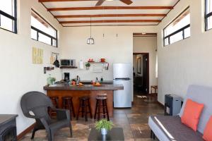 a kitchen with a counter and a kitchen with a refrigerator at Villa Victoria, Valle de Guadalupe in Valle de Guadalupe