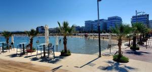 a pool of water with palm trees and a beach at Apart-Hotel Suites - Qerret, Golem, Durres in Golem