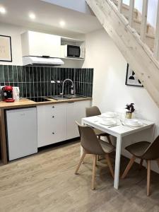 a kitchen with a table and chairs and a sink at 734 Elégant studio en mezzanine proche du métro L9 in Bagnolet