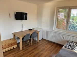 a room with a table and chairs and a television at Penzion Baffi in Topoľníky