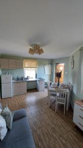 ein Wohnzimmer mit Tisch und Küche in der Unterkunft OcypLoveDomki, Ocypel - Bory Tucholskie, Balia in Ocypel