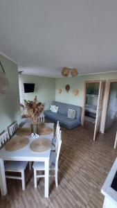 ein Wohnzimmer mit einem Tisch und einem blauen Sofa in der Unterkunft OcypLoveDomki, Ocypel - Bory Tucholskie, Balia in Ocypel
