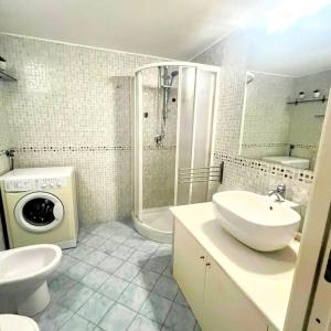 a bathroom with a sink and a washing machine at Casa Nina-Bacoli Elegant & View in Bacoli