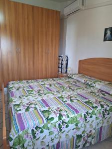 a bedroom with a bed with a floral quilt on it at Casa Concetta in Noto Marina