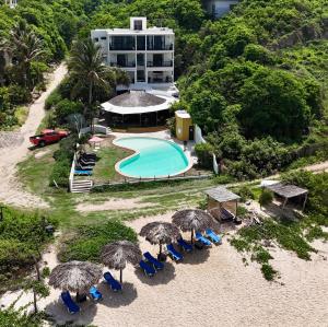 an aerial view of a resort with a swimming pool and umbrellas at Manta Raya Hotel - right on the beach in Cuatunalco