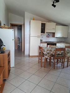 a kitchen with a table and chairs and a white refrigerator at Casa Concetta in Noto Marina +28 photos