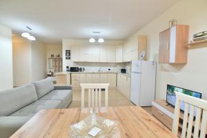 a kitchen and living room with a couch and a table at Geny's House in Shkodër