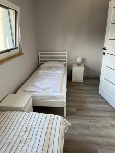 a small bedroom with two beds and a window at Palm Beach in Dziwnówek +8 photos