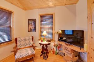 a living room with a television and a chair at Cozy Beattyville Cabin with Fire Pit and Hot Tub in Beattyville