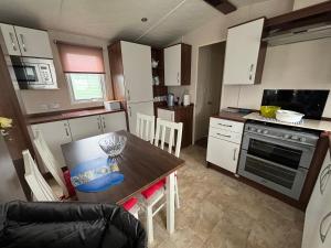 a small kitchen with a wooden table and a dining room at Coyles retreat in Stranraer