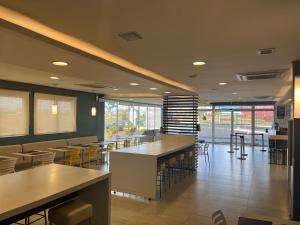 a dining room with tables and chairs in a restaurant at Golden Tower Aeroporto - Lizz - by Fênix Hotéis in Uberlândia