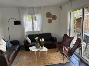 a living room with a couch and chairs and a table at Cosy Villa Arcachon Bay in Audenge