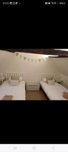 - 2 lits dans une chambre avec drapeaux sur le mur dans l'établissement Kingsgate Cottage, à Winchester 1 autre photo