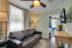 a living room with a leather couch and a ceiling fan at The Cabernet Cabin Defiance Home on Katy Trail! in Defiance