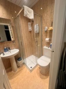 a bathroom with a shower and a toilet and a sink at Fairhaven Holiday Flats in Blackpool +51 photos