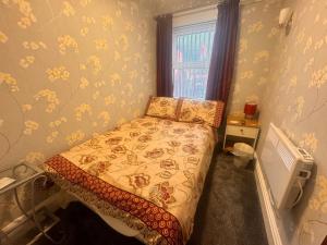 a small bedroom with a bed and a window at Fairhaven Holiday Flats in Blackpool