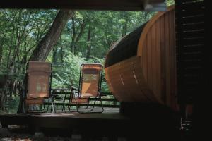 zwei Stühle und ein Boot auf einem Tisch in der Unterkunft NASU terrace MANA 森のバレルサウナとBBQグリル in Nasu + 42 Fotos