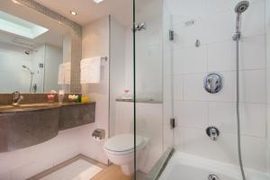 a bathroom with a shower and a toilet and a sink at Leonardo Plaza Hotel Tiberias in Tiberias