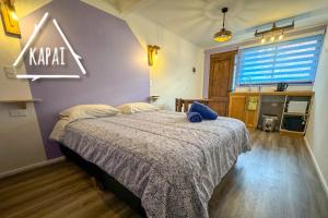 Un dormitorio con una cama con un cartel en la pared. en Kapai Departamentos de Turismo, en Valdivia