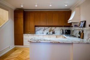 a kitchen with wooden cabinets and a marble counter top at Koçin Konak Luxury Boutique Home in Soğuksu