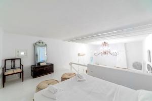 a white room with a table and a mirror at MichaelAngelo Villa in Mýkonos City +22 photos