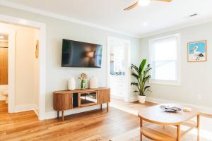 a living room with a tv and a table at NEW! 1937 Coastal Cottage by Beach, Boardwalk, & Lake! in Carolina Beach