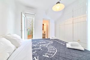 a white bedroom with a large bed with white pillows at MichaelAngelo Villa in Mikonos +22 photos