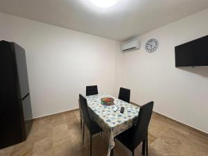 tavolo da pranzo con sedie e orologio sul muro di Casa felicità Sciacca a Sciacca Altre 2 foto