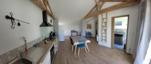 a kitchen and living room with a table and chairs at le Wacapou in Courpignac
