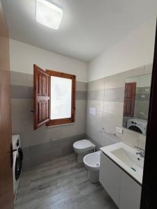 un bagno con un water, un lavandino e una finestra di Casa felicità Sciacca a Sciacca