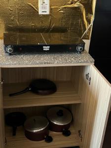 a cabinet with a tv and some pots and pans at Porto Sharm Pool View VIP-Service in Sharm El Sheikh