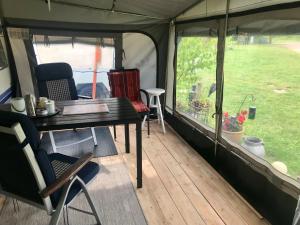 a table and chairs in a tent at Komfort-Caravan mit Vorzelt in Loitz